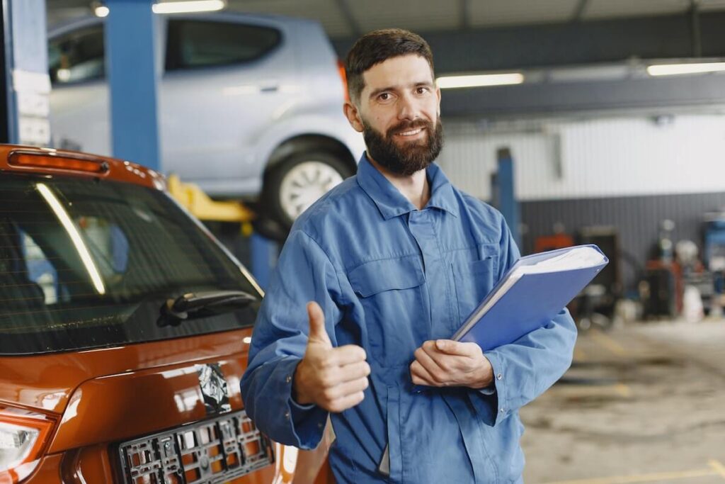 Mechanic giving a thumbs up to a car