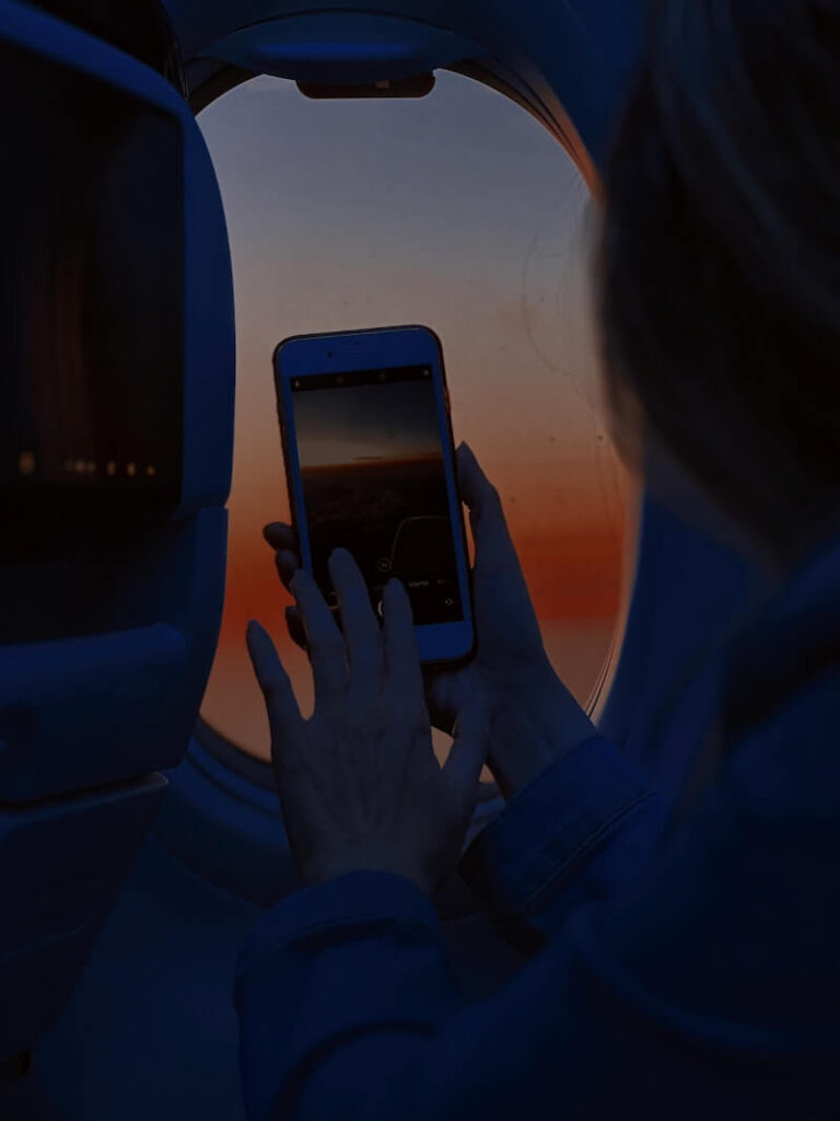 woman taking a picture from an airplane window with her phone