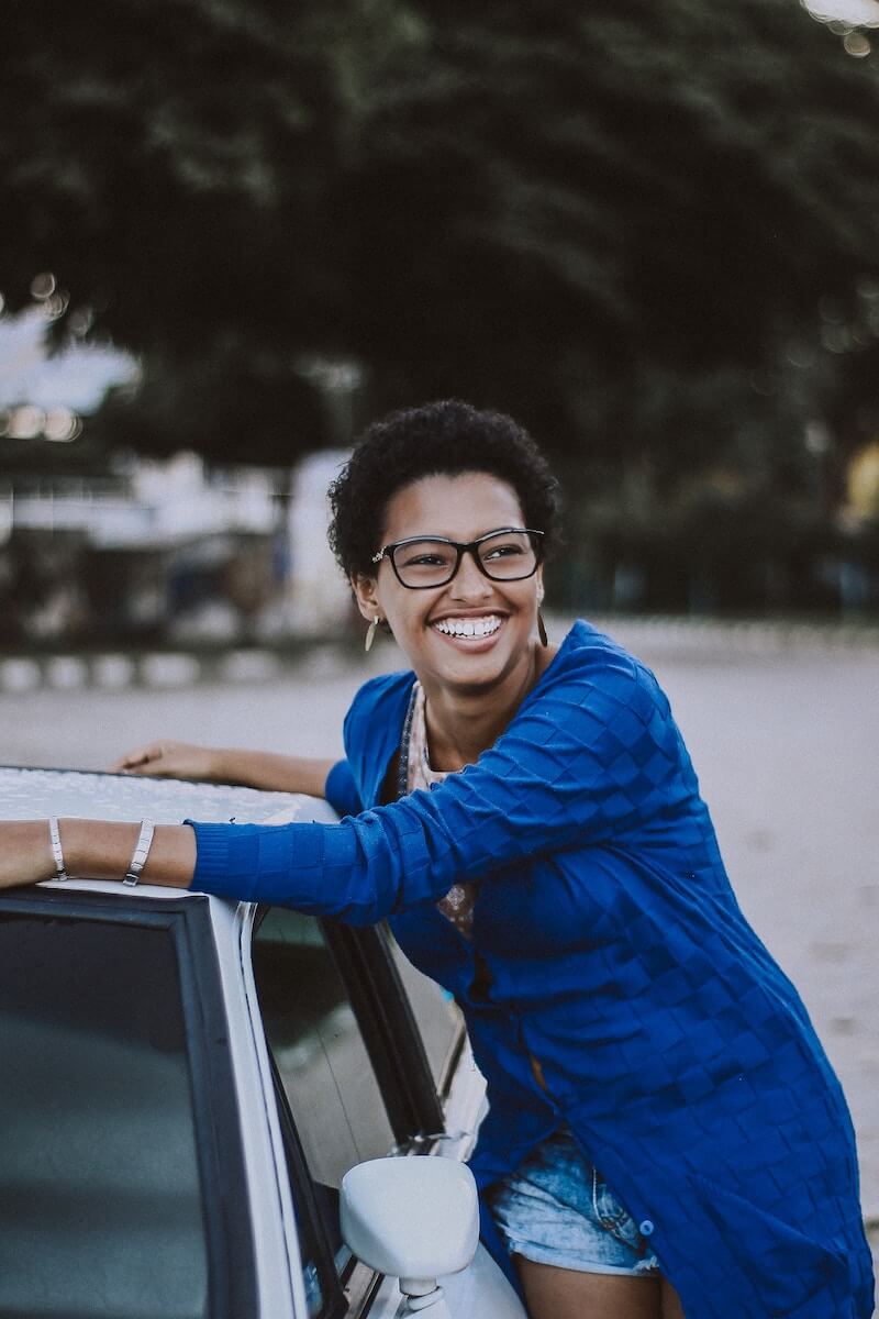 woman stands near a car