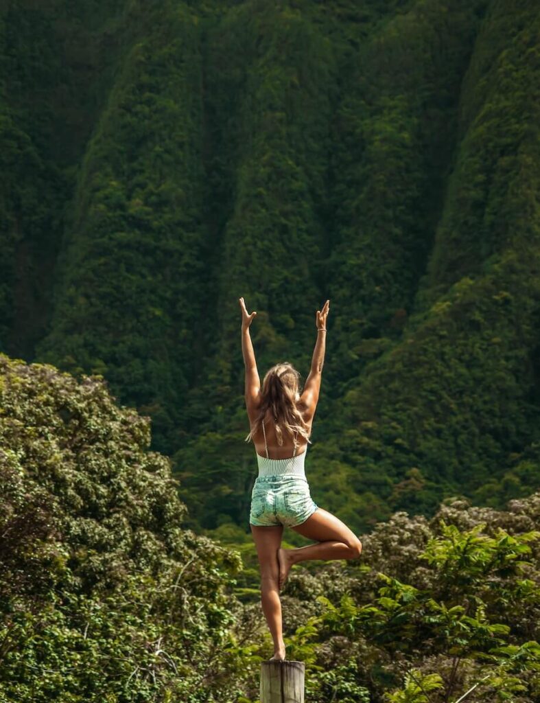 Woman doing yoga out in nature as part of a digital nomad lifestyle